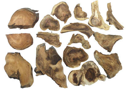 An overhead view of many assorted, irregularly shaped wood pieces with prominent grain and dark knots.
