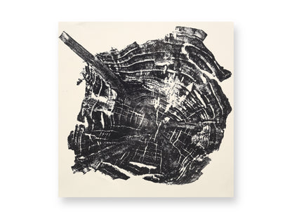 Impression of an irregular tree root slice in black, revealing concentric growth rings and a diagonal root.