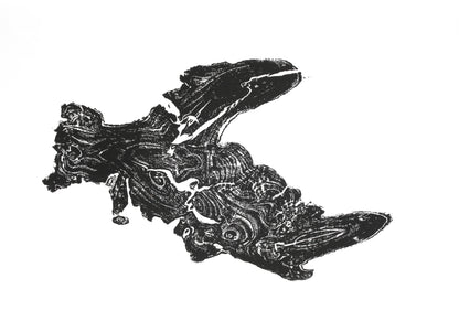 Irregularly shaped dark woodcut impression of a tree root showing detailed organic swirling patterns on white paper.