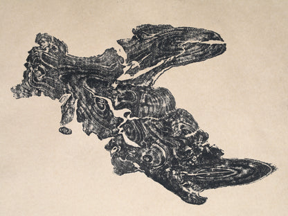 A dark, irregularly shaped tree root impression monoprint with detailed organic grain patterns on light beige paper.