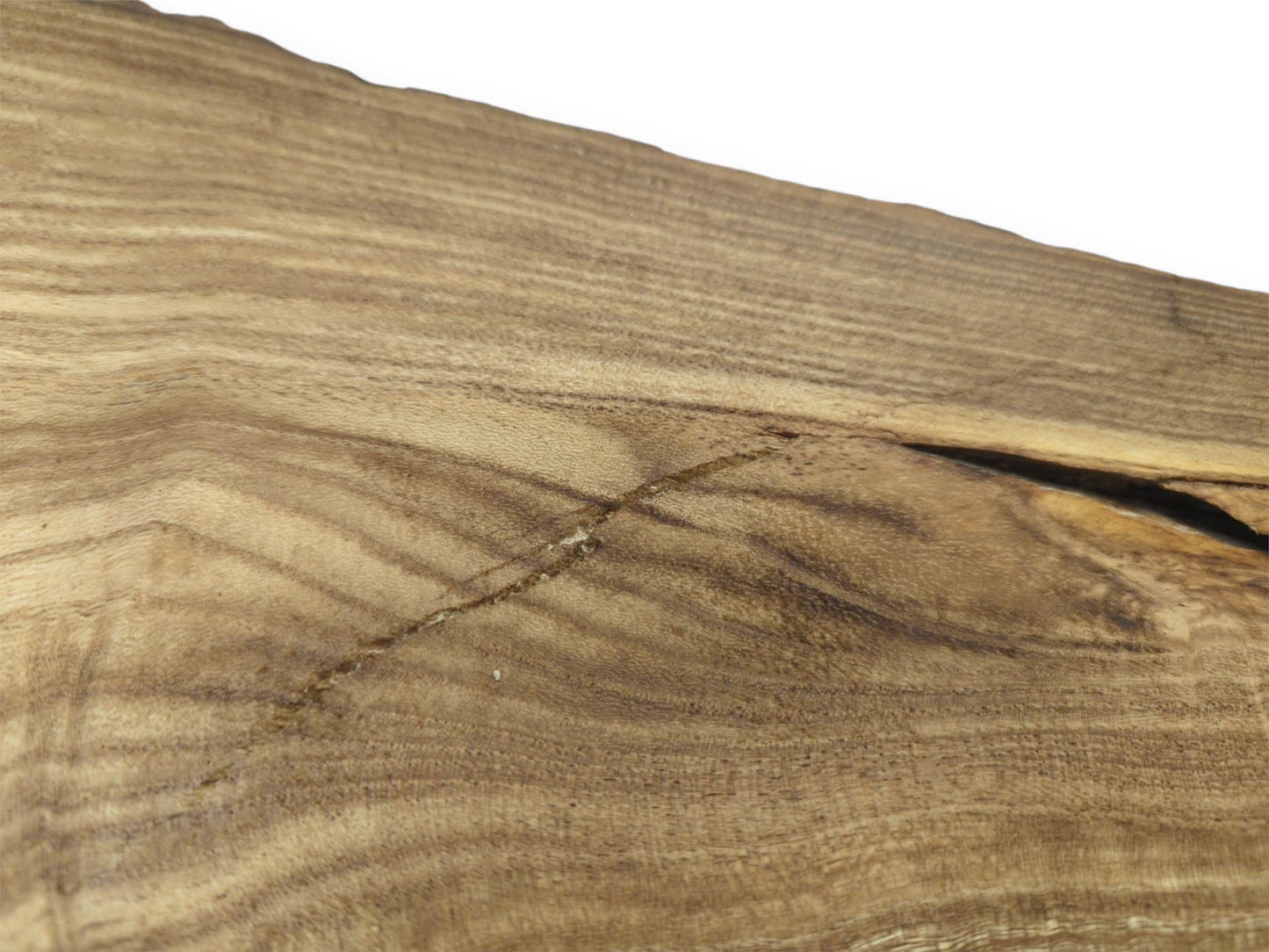 A diagonal scar cuts across the straight grain of a timber slab near a dark fissure.