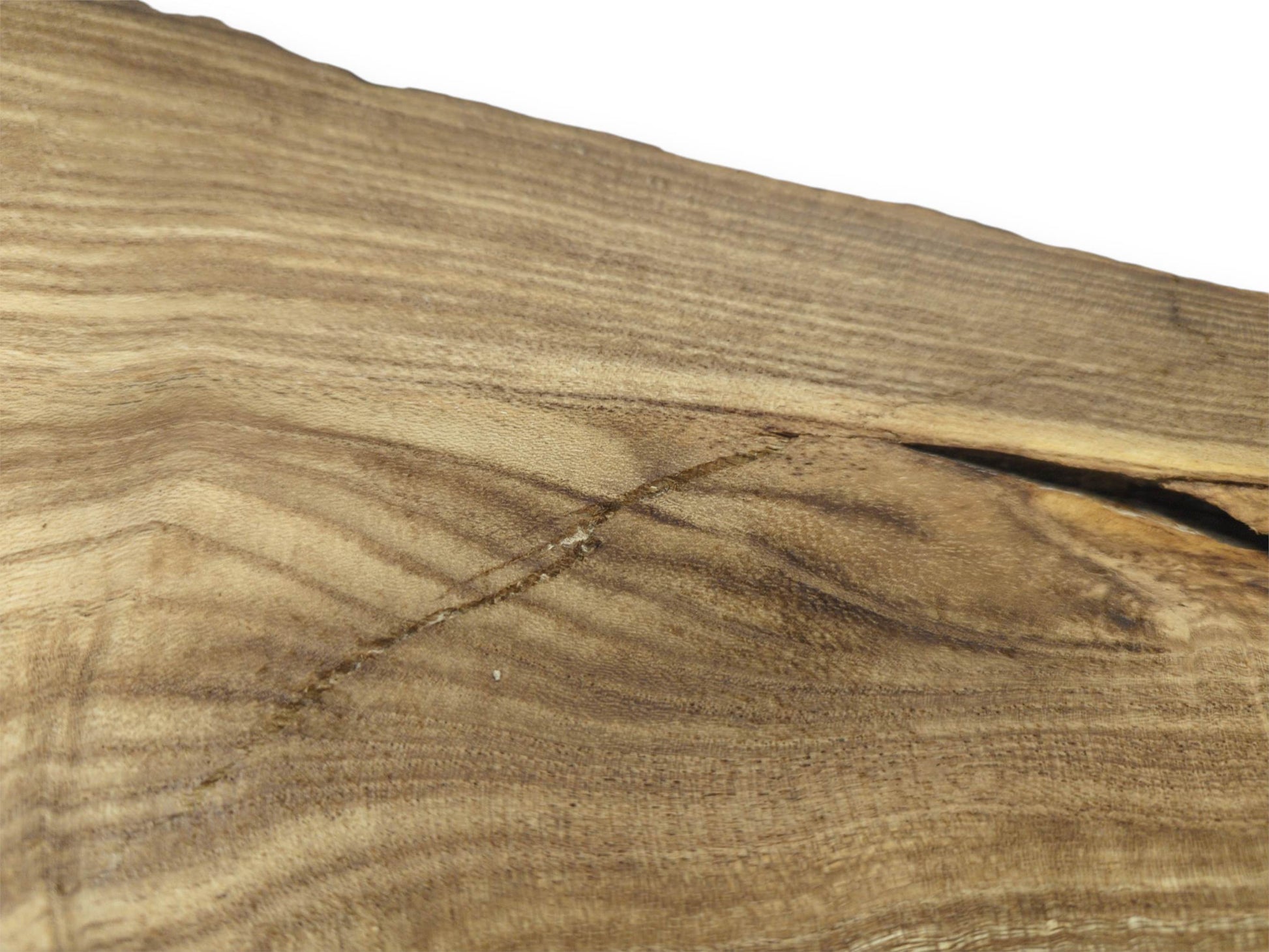A diagonal scar cuts across the straight grain of a timber slab near a dark fissure.