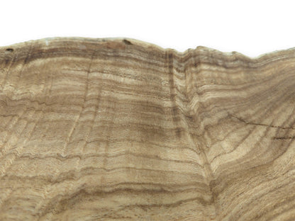 Rippling bands of light and dark grain flow toward an irregular, natural top edge.