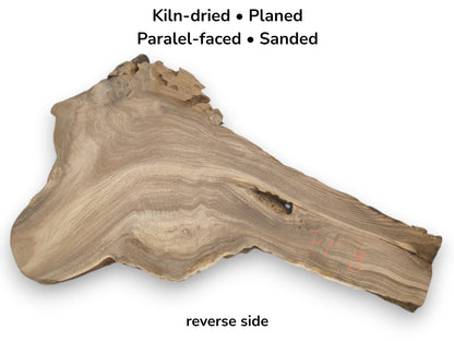 An irregular timber blank shows parallel grain, a jagged top edge, and a single void.