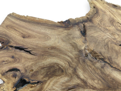 Dark, branching fissures cut through the swirling, topographic grain of a finished timber section.