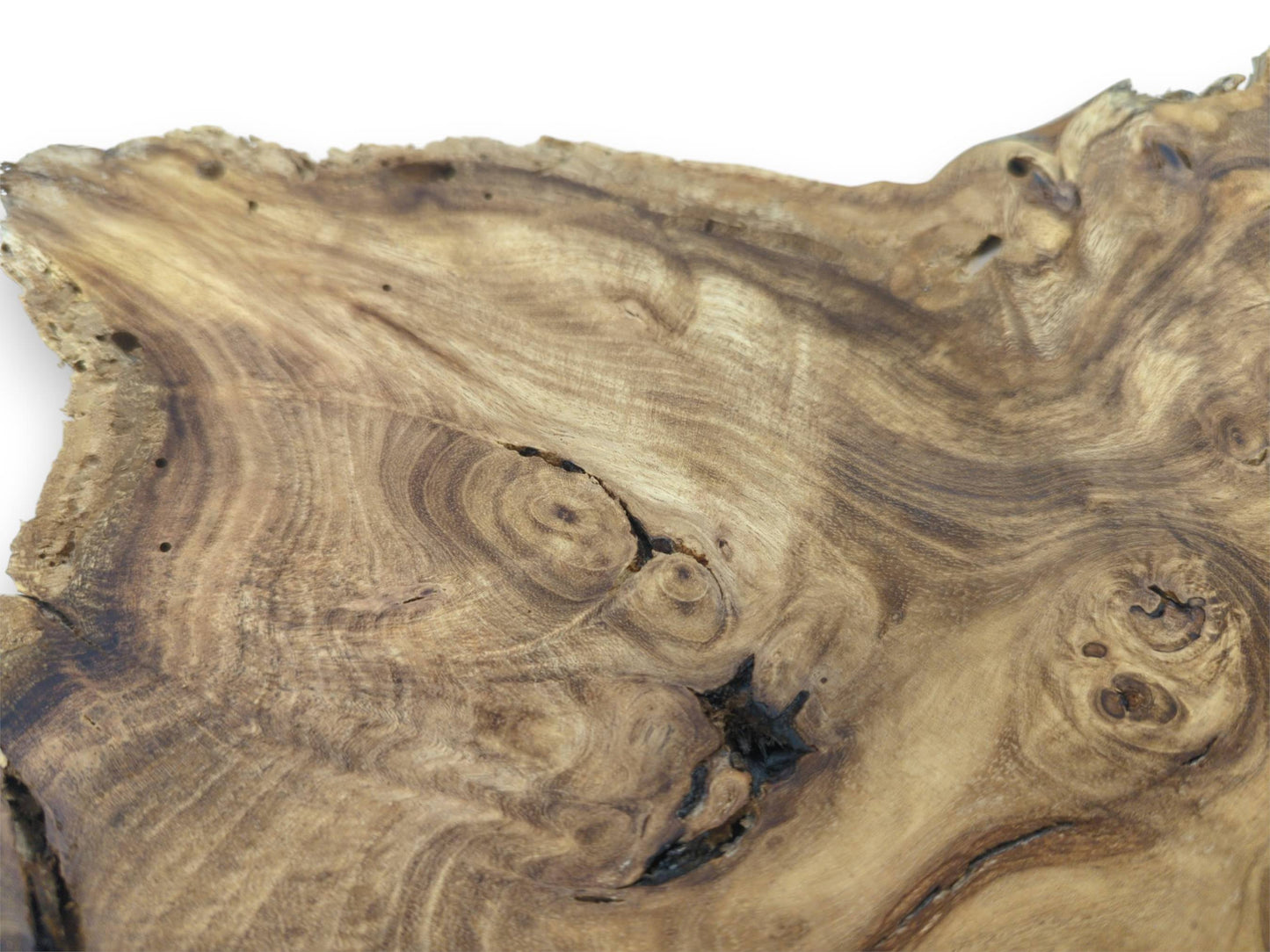 A dark, jagged void and multiple burls interrupt the timber's flowing, contoured grain.