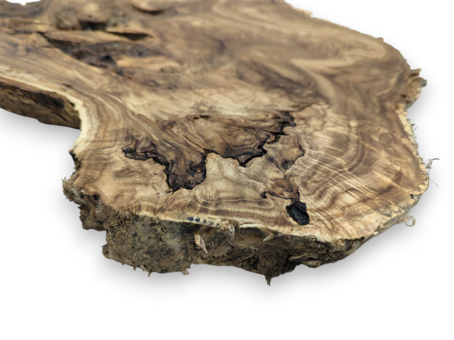 A low-angle view of a figured timber slab with swirling grain and dark, map-like voids.
