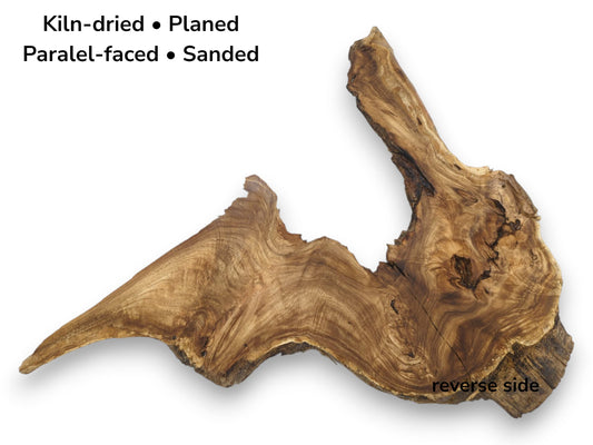 A flat-lay view of a root slab with dramatic wavy grain and a dark burl.