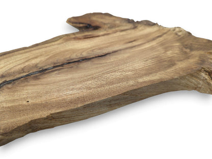 An angled perspective on a finished lumber plank highlights a dark fissure and fine grain.