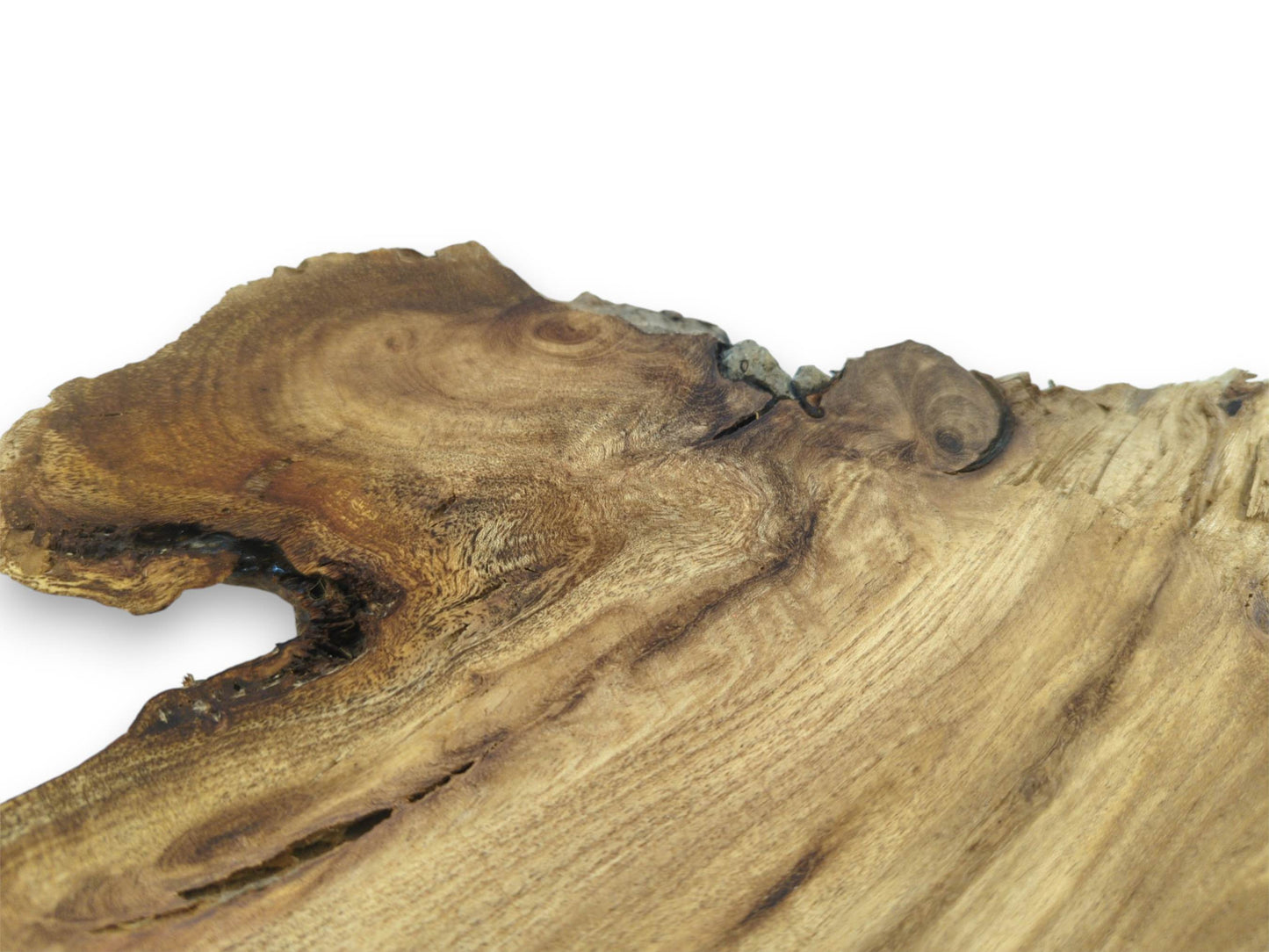 A dramatic, swirling grain pattern flows around a deep hollow on a finished wood slab.