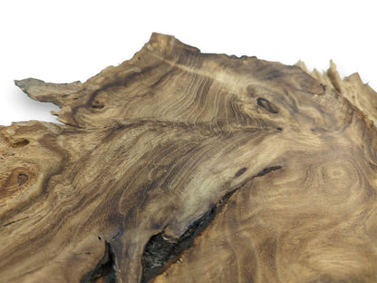 A close perspective on a wood slab shows contoured grain flowing around a dark chasm.