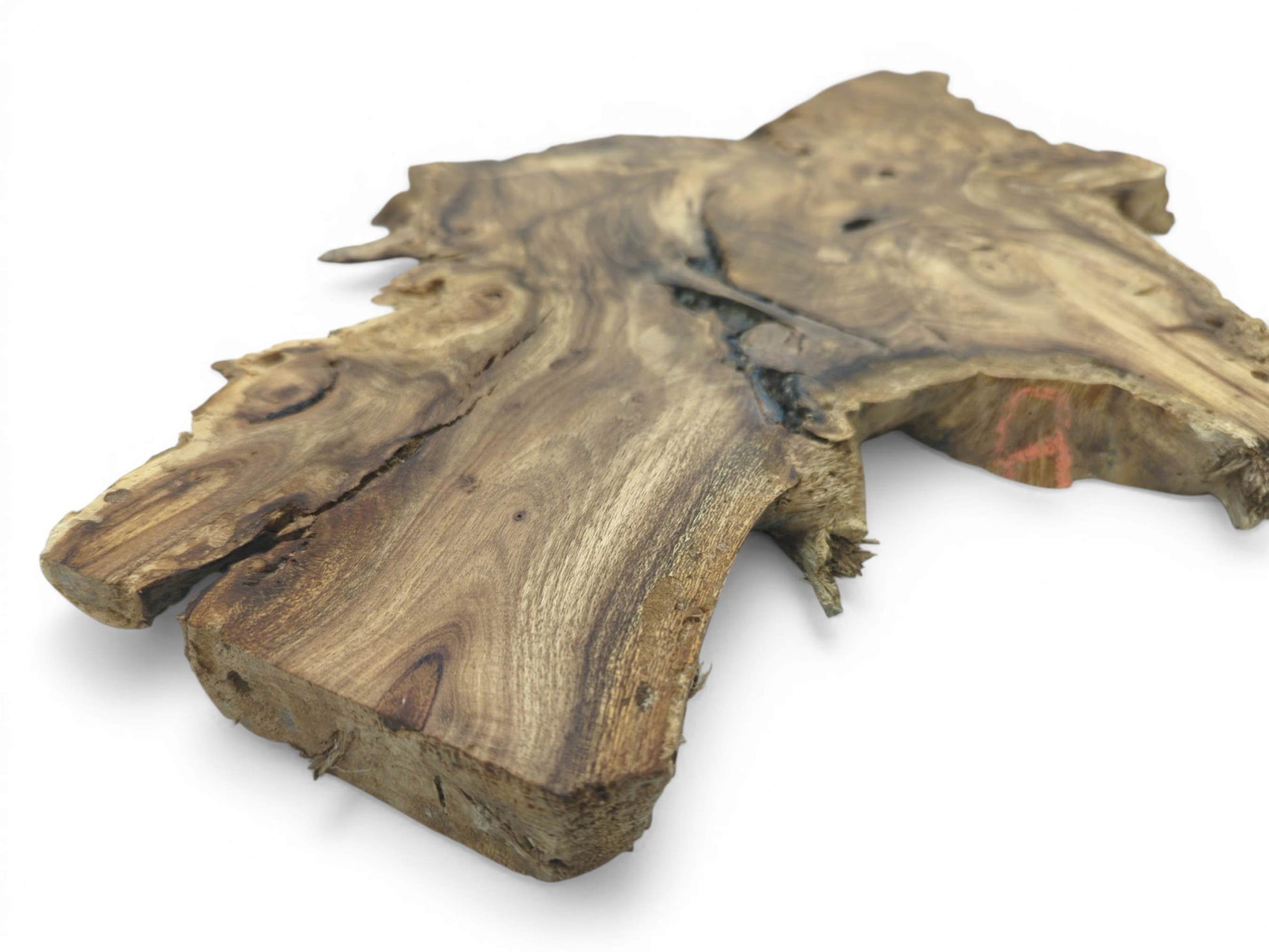 A low-angle view of a thick timber section shows its rugged live edge and linear grain.