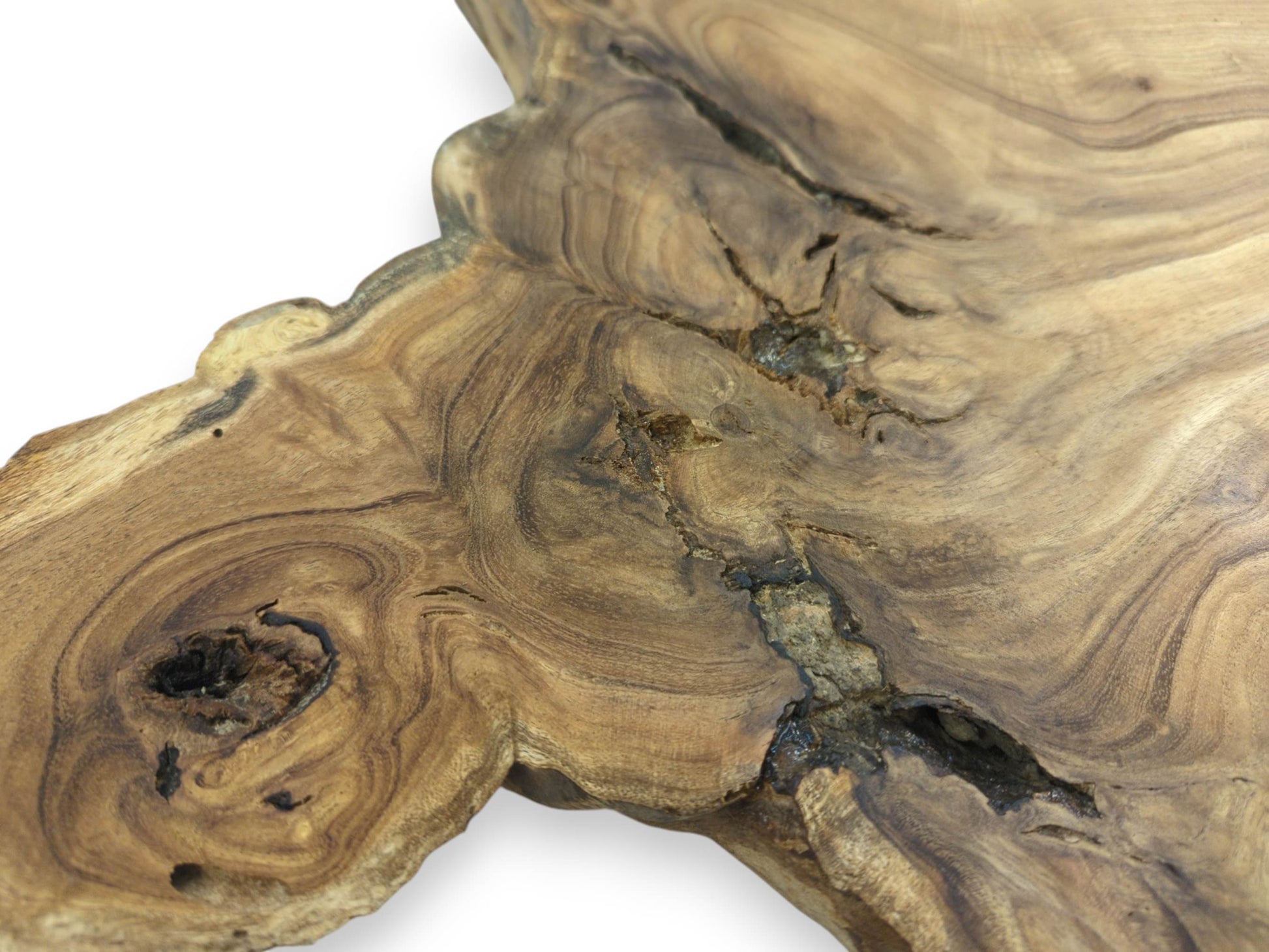 A dark, hollow knot and a deep central fissure interrupt the swirling grain of a wood slab.