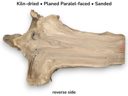 A planed timber section shows contoured grain flowing from a gnarled base to a straight-cut edge.