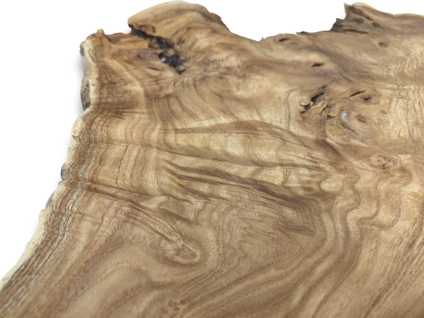 A close-up on a raw timber slab reveals undulating grain and a dark, knotty void.