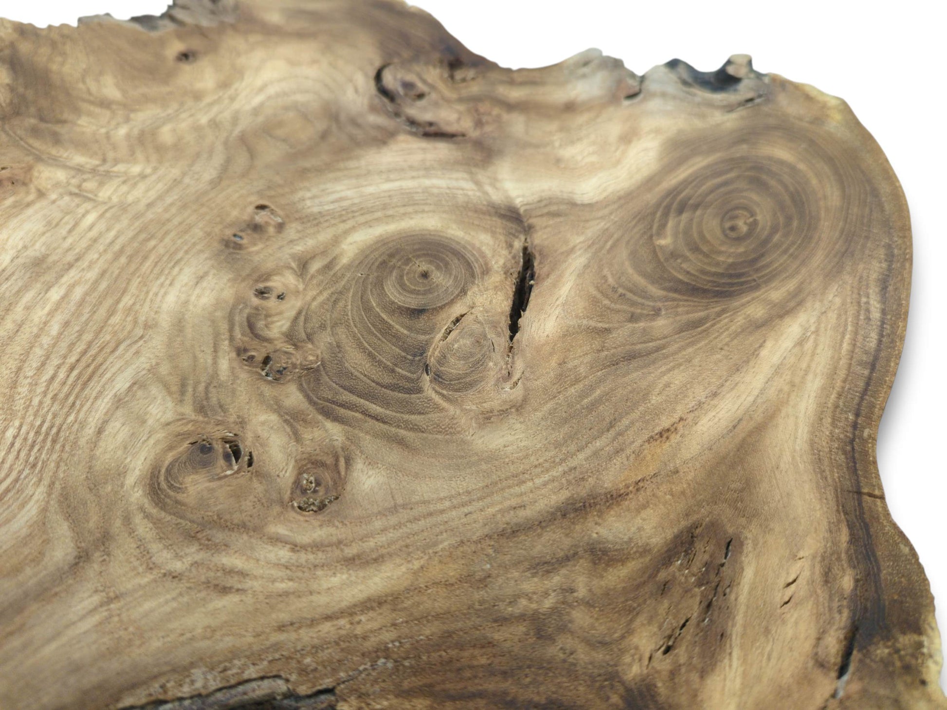 A hardwood cross-section reveals hypnotic, swirling burls and a prominent dark central fissure.