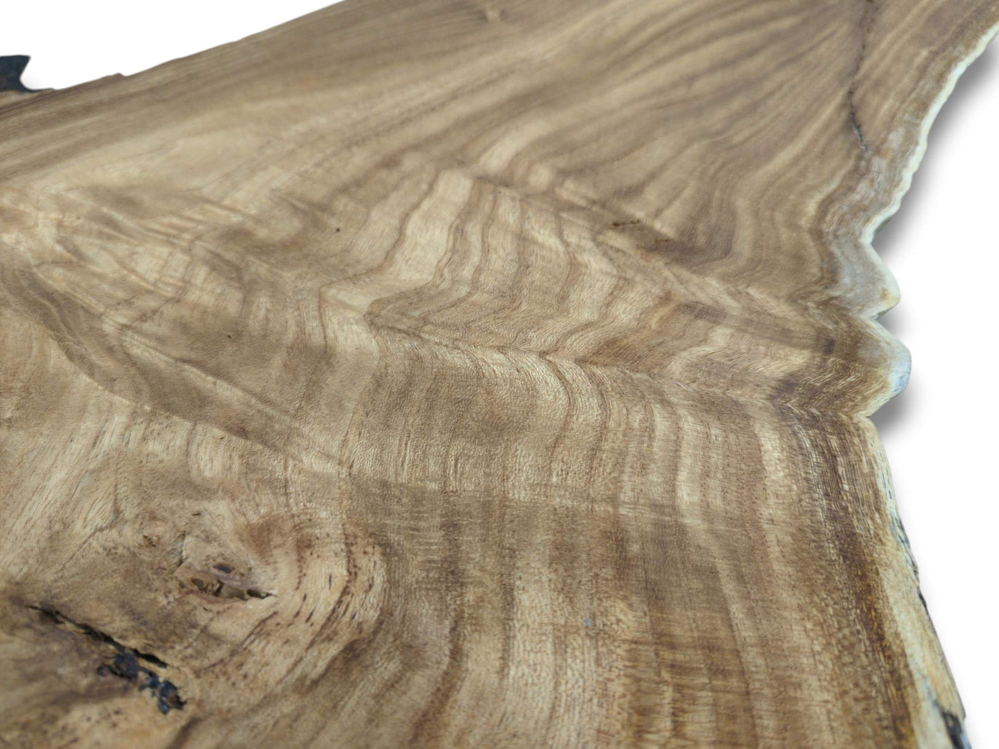 An angled view across a hardwood plank reveals its undulating grain and a single dark knot.