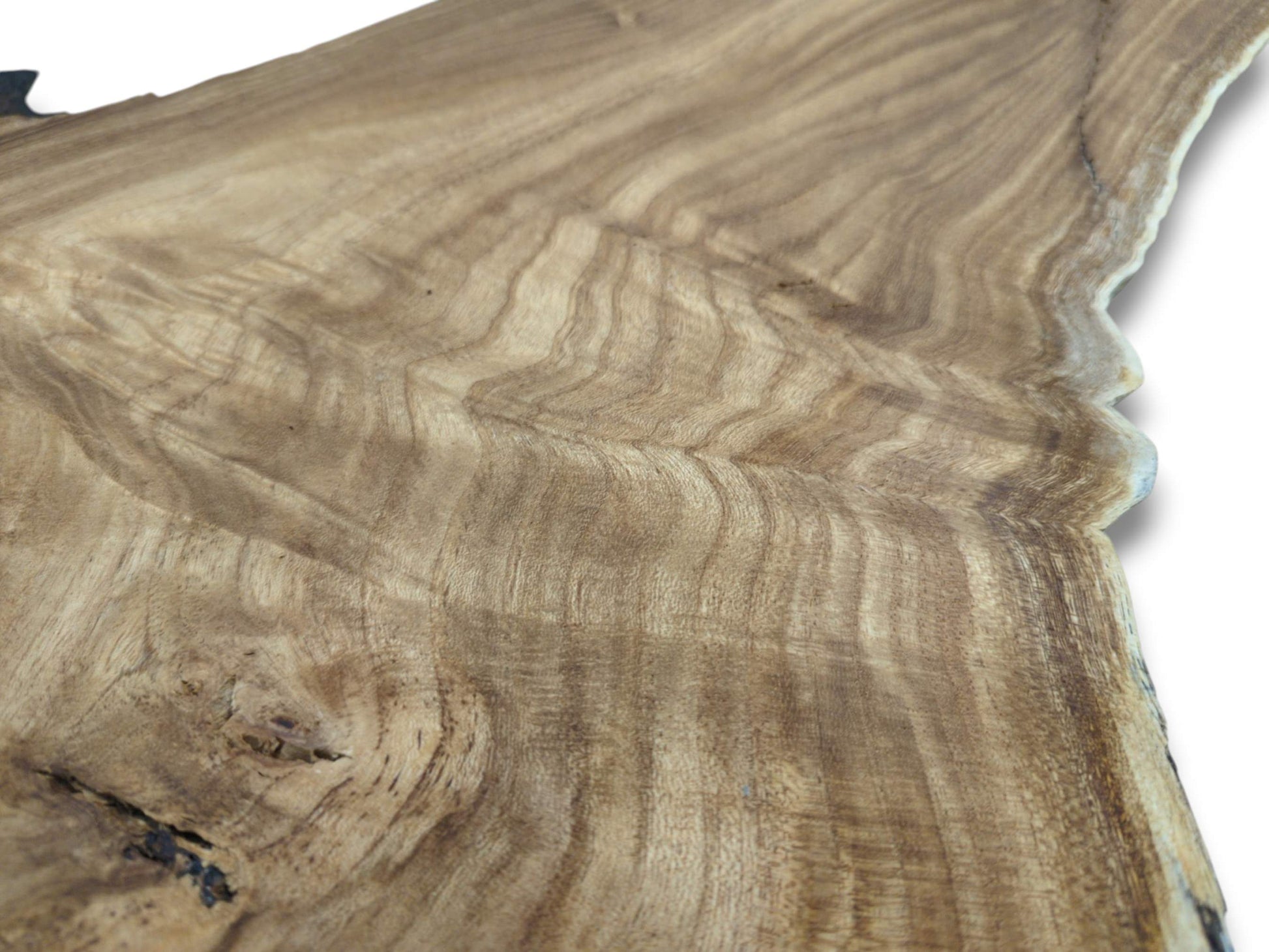 An angled view across a hardwood plank reveals its undulating grain and a single dark knot.
