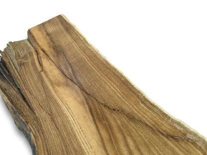A long fissure runs diagonally across a raw lumber plank with a rough, splintered end.