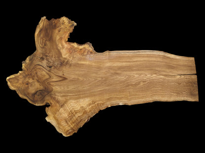 A long wood plank features a wide, gnarled end with eye-like grain patterns.