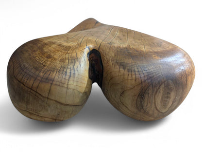 Organic, hand-carved wooden heart, brown with prominent natural grain, visible cracks, and oiled finish.