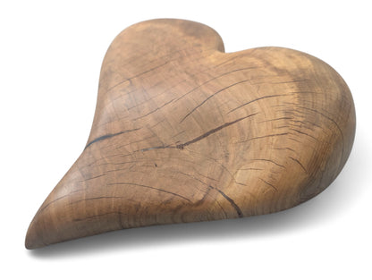 Heart-shaped sculpture, hand-carved from solid hardwood, displaying natural wood grain, cracks, and an oiled finish.