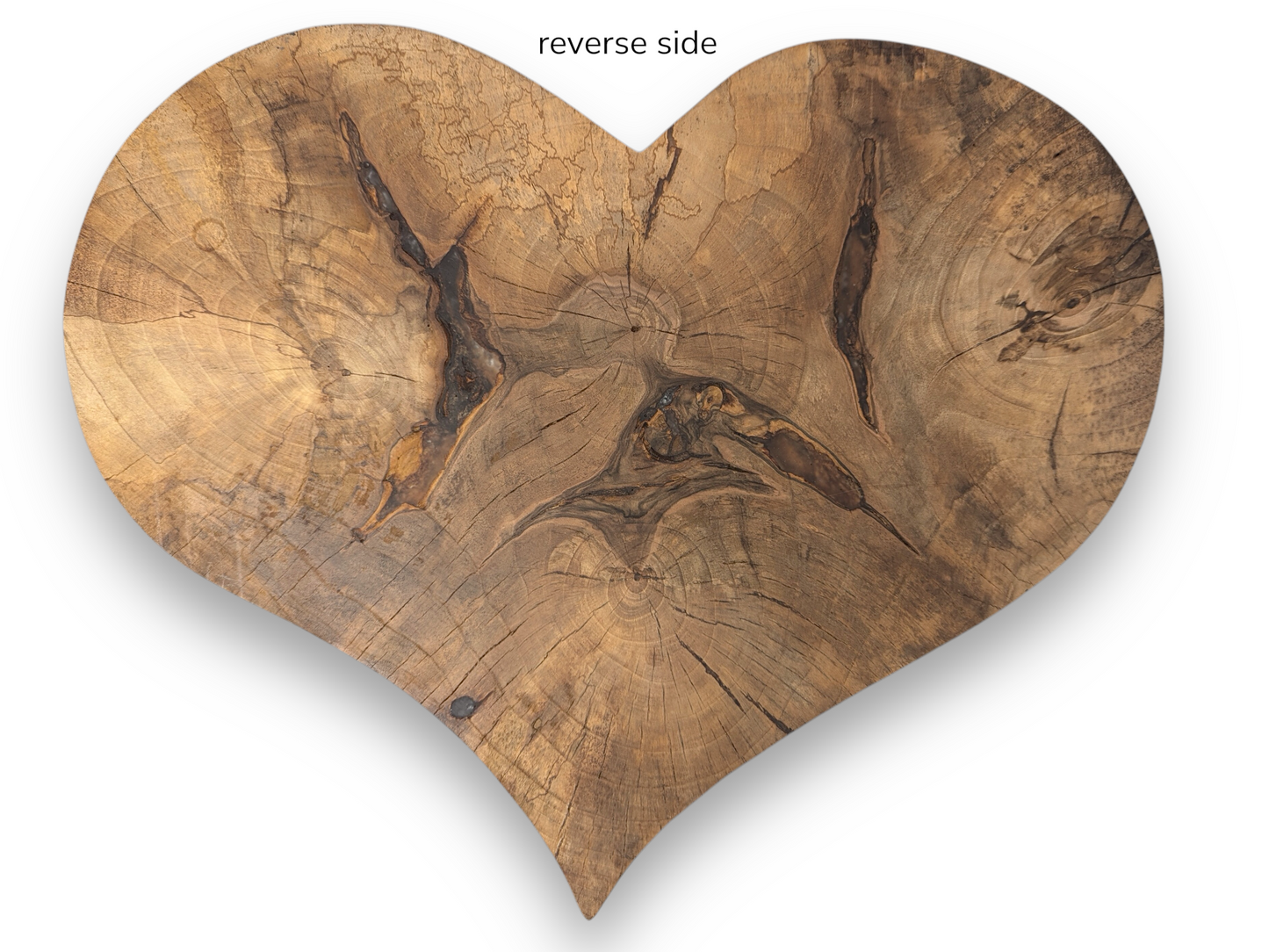 Reverse side of a heart-shaped wood slab, displaying natural grain, prominent knots, and cracks.