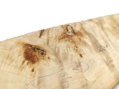 A dark, textured knot and a smaller burl interrupt the pale, swirling woodgrain.