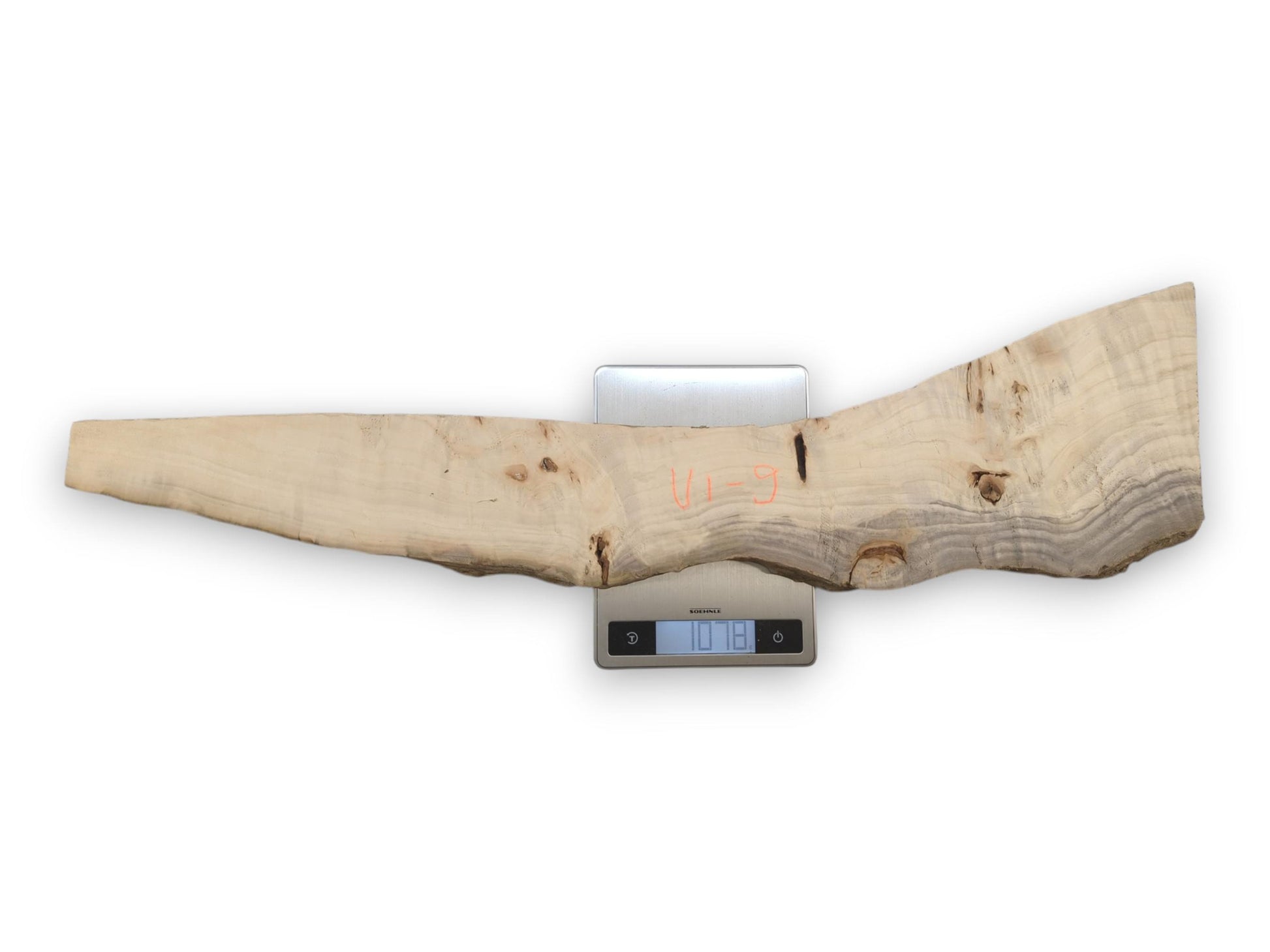 An overhead view shows a long, irregular wood plank with grey grain on a scale.