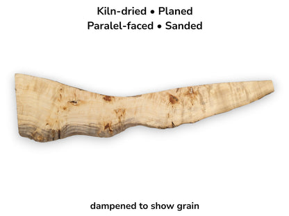 A long, light-toned poplar slab features a dark, undulating live edge and scattered knots.