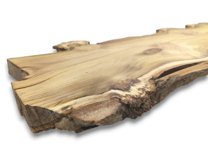 A close-up, low-angle view of a live edge black locust wood slab on white.