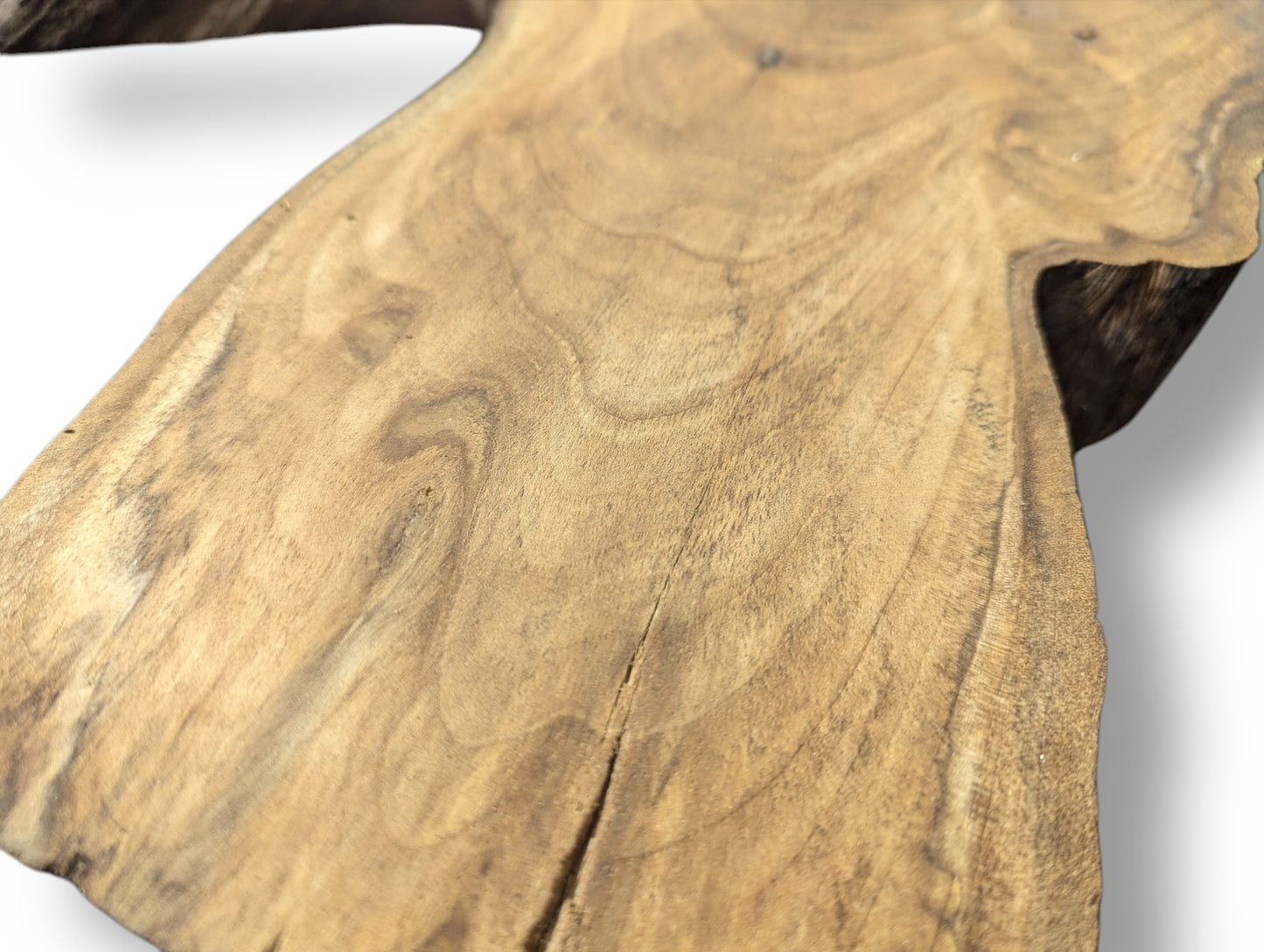 Close-up image of a light brown wood slice, showing swirling grain patterns, a small crack, and a dark live edge.