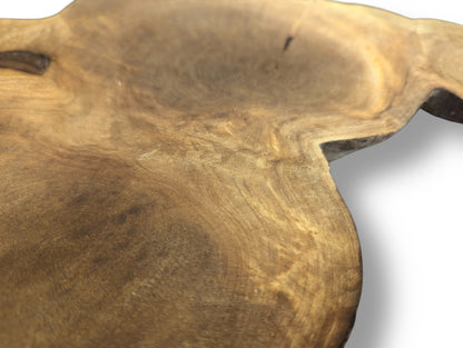 Close-up of an irregular brown wood slice with intricate swirling grain patterns and a visible natural live edge.