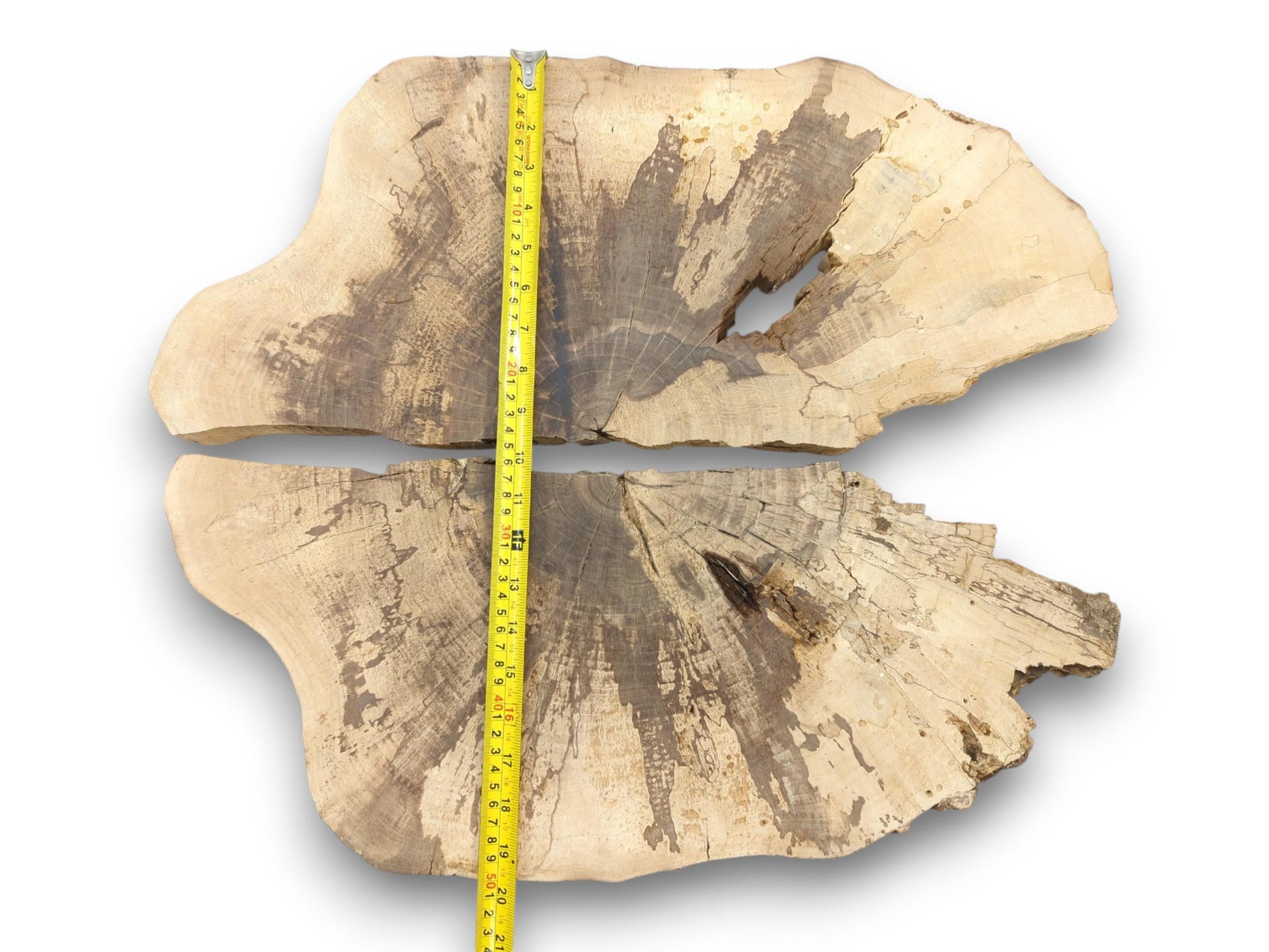 A yellow measuring tape is laid over two light walnut slabs to show their combined vertical dimension.