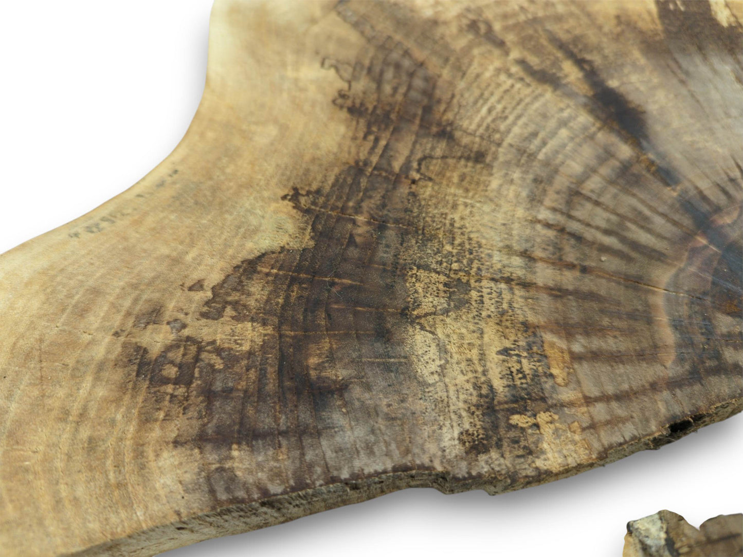 A detailed macro shot captures the dark, blotchy wood grain spreading over a light walnut slab.