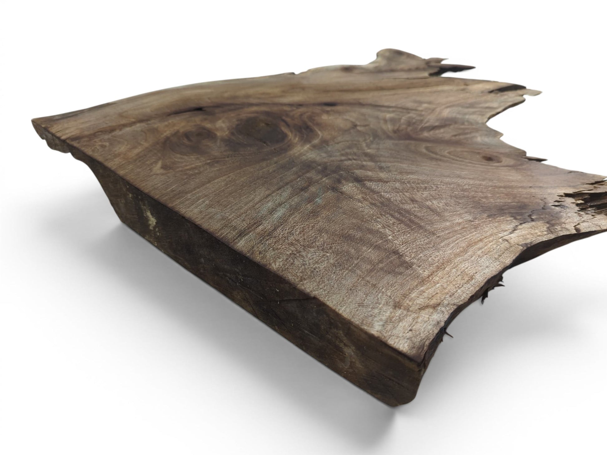 A natural live edge walnut wood slab with prominent grain patterns and a rough, organic shape.