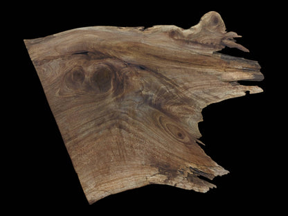 A natural live edge walnut wood slab with prominent grain patterns and knots on a black background.