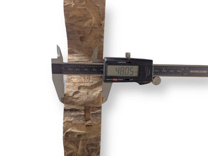 Textured, irregular, light brown weeping willow wood slice being measured by a digital caliper showing 48.05mm.