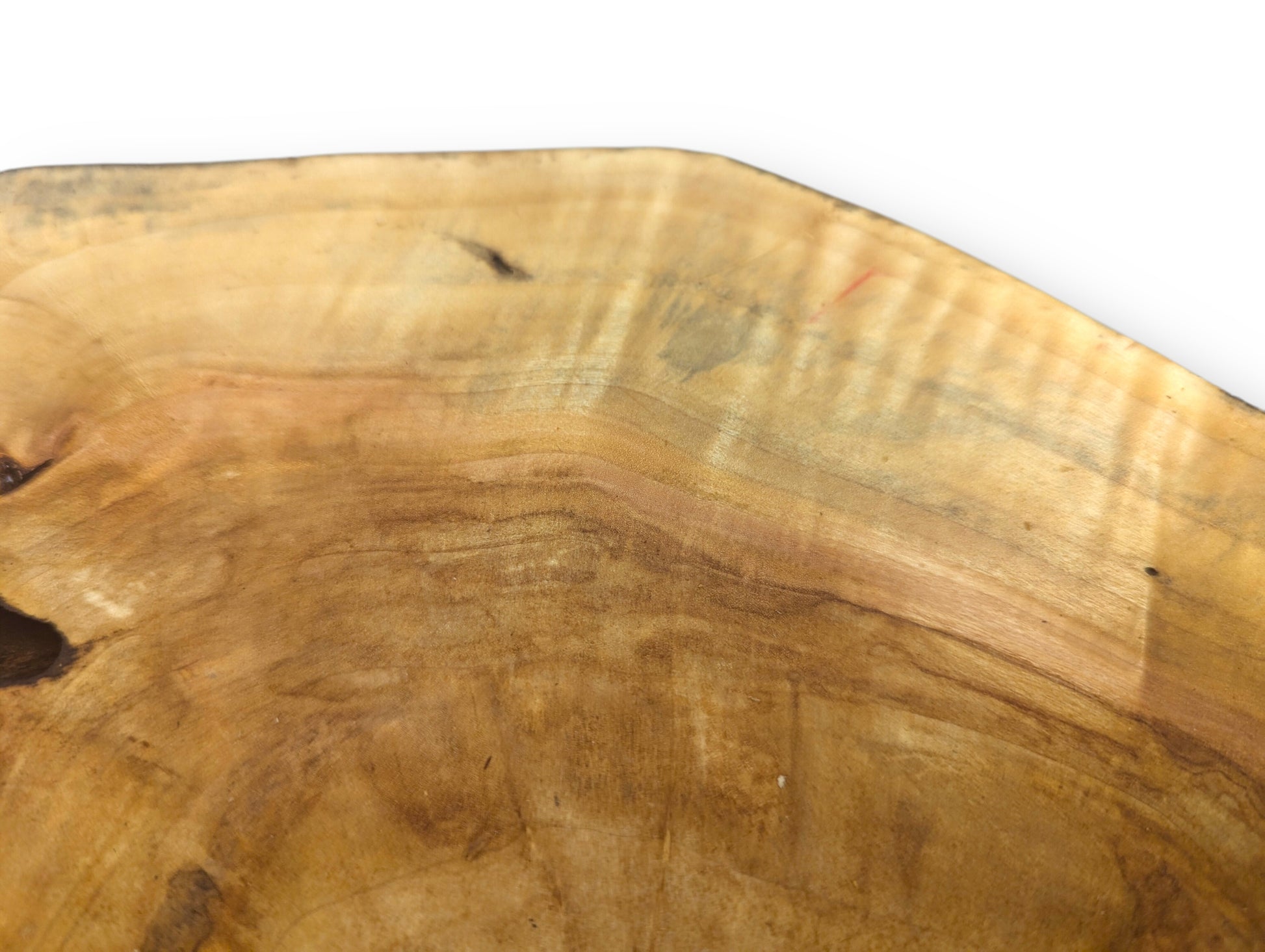 Smooth golden brown wood slice with irregular live edge, displaying distinct wavy grain patterns and dark markings.