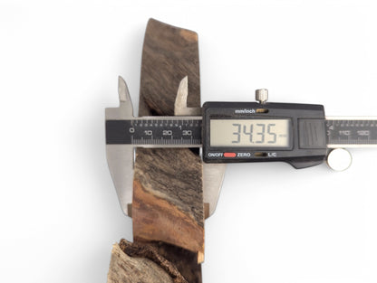 Digital caliper measures a dark brown and reddish-brown wood slice, displaying a thickness of 34.35 mm.