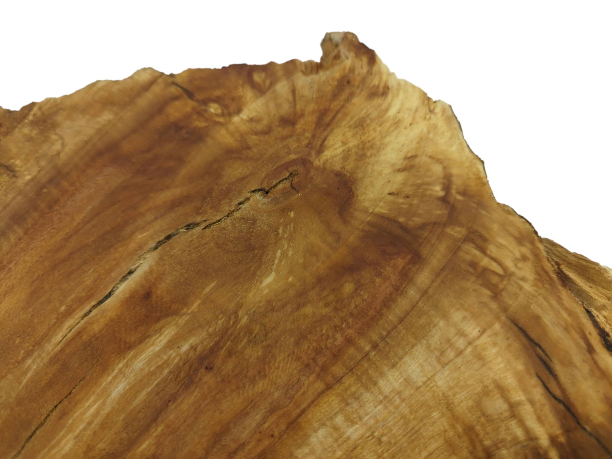 A close-up, angled view of a light brown wood slab with a live edge and natural cracks.