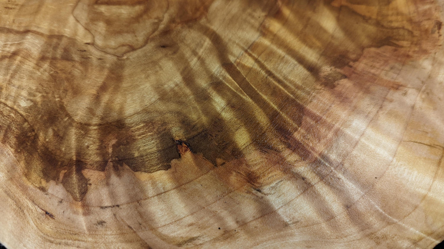 Detailed view of the golden-brown wood surface, featuring distinct wavy grain patterns and dark streaks.