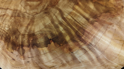 Detailed view of the golden-brown wood surface, featuring distinct wavy grain patterns and dark streaks.