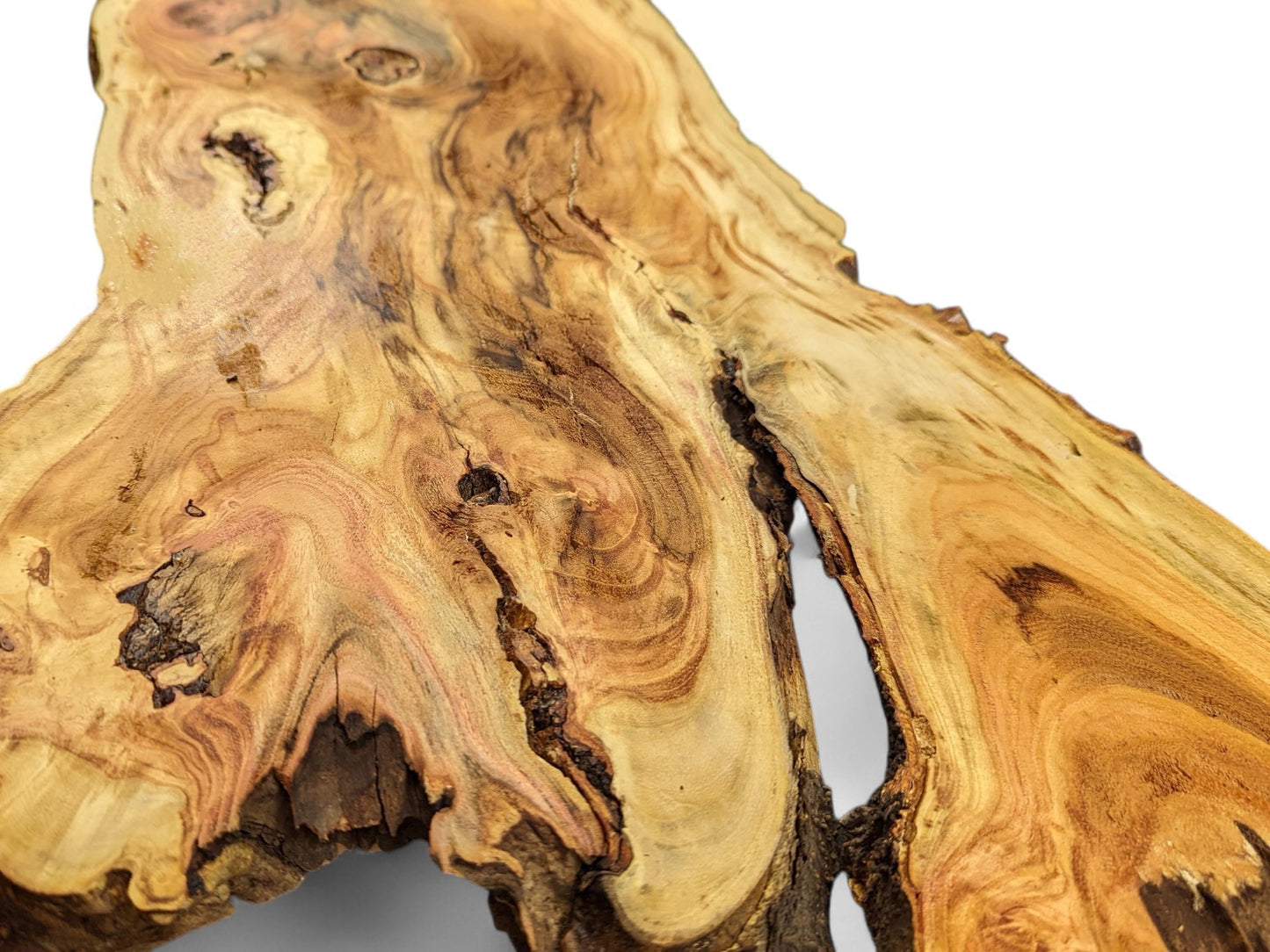 Irregular live edge wood slice with golden-brown colors, prominent swirling grain, and a deep natural fissure.