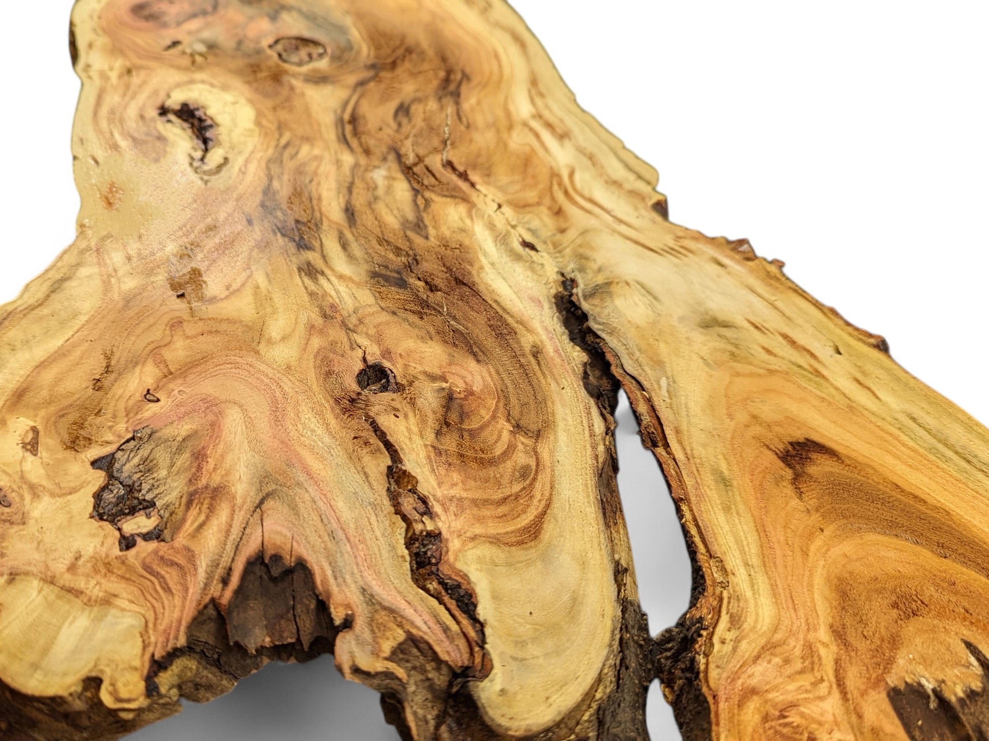 Irregular live edge wood slice with golden-brown colors, prominent swirling grain, and a deep natural fissure.