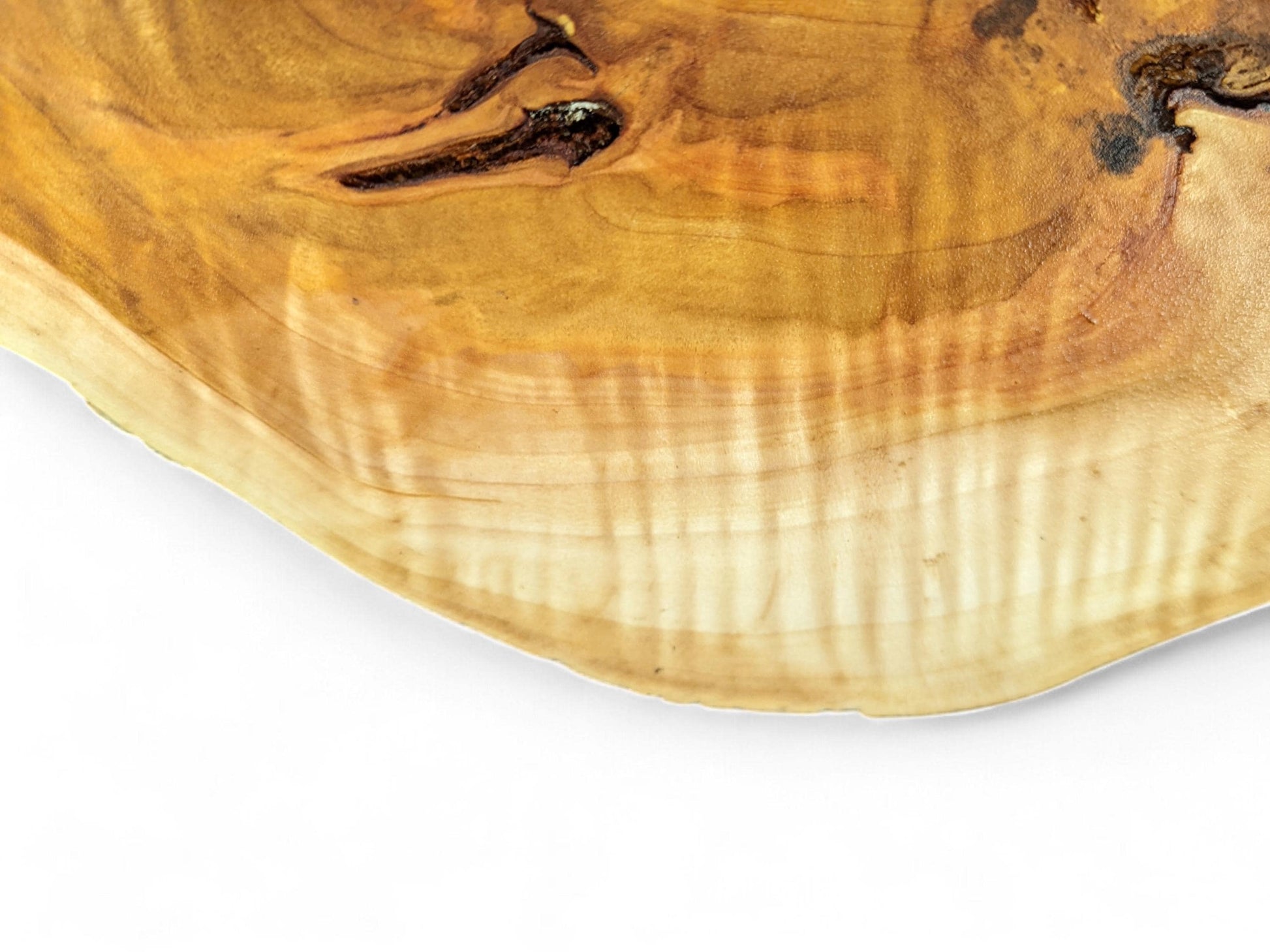 Golden-brown wood slab close-up, revealing natural knots, distinct grain, and lighter, striped sapwood.