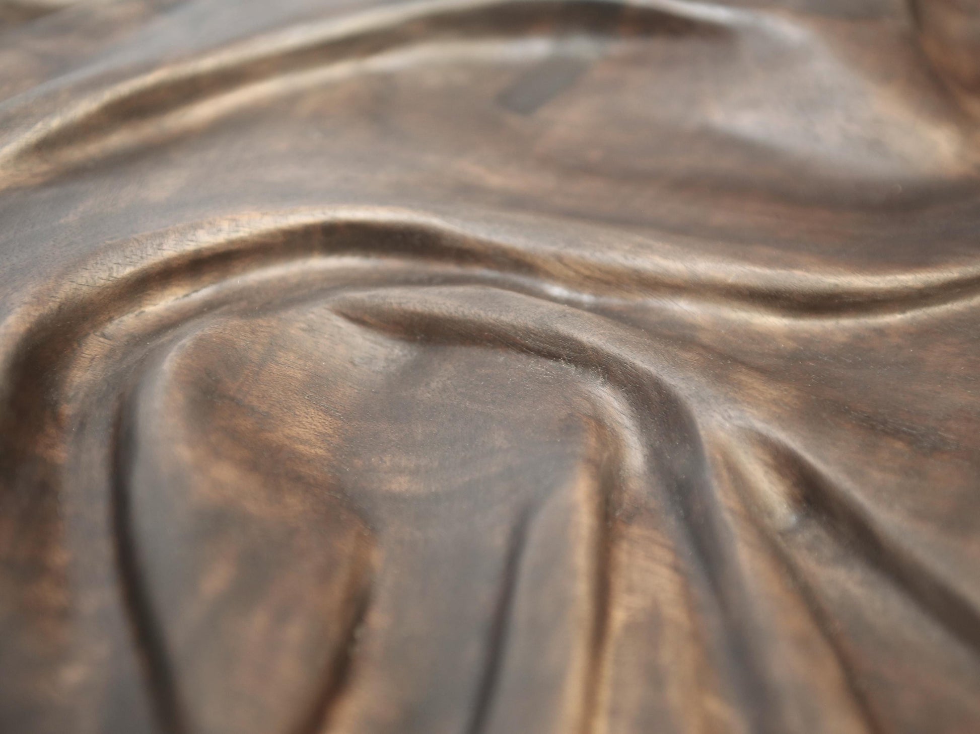Carved natural solid walnut wall art featuring dark brown, undulating fabric-inspired relief with an oil finish.