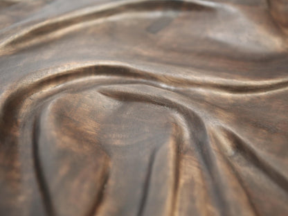 Carved natural solid walnut wall art featuring dark brown, undulating fabric-inspired relief with an oil finish.