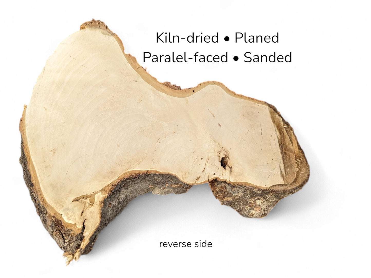 Reverse view of smooth beige wood slab with dark bark borders and text indicating processing details.