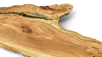 Close-up of an irregular live edge golden-brown honey locust wood slice with prominent grain patterns and dark crevices.